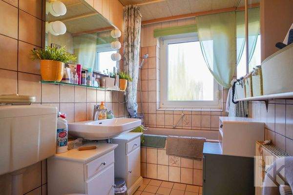 Das Badezimmer mit Badewanne und großem Fenster