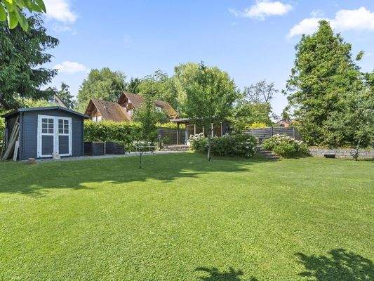 hinterer Gartenbereich mit zwei Gartenhäusern und Hochbeeten