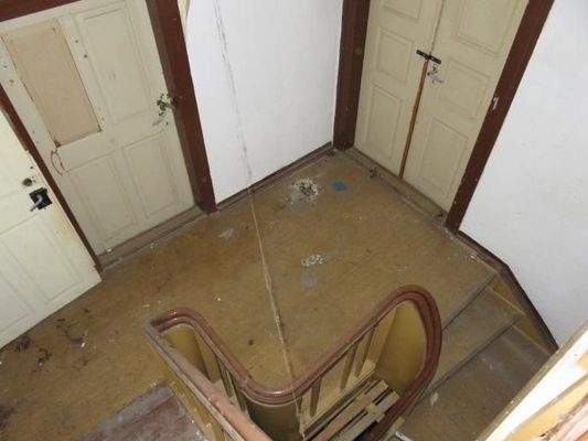 Treppenhaus Blick auf das Obergeschoss, beide Türen führen in den Saal