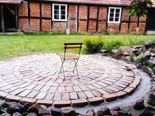 Pflasterrondell unter schattigen Bäumen