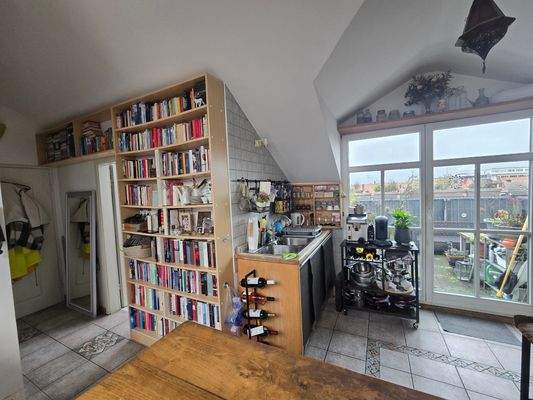 Diele mit großem Bücherregal und Blick auf Balkon und offener Küche.jpg