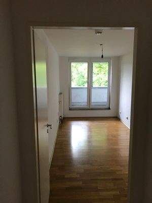 Schlafzimmer mit weißen Wänden und Parkettboden