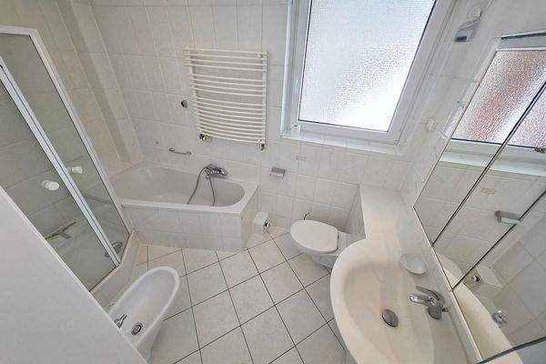 Das in Weiß gehaltene Hauptbad mit Tageslicht