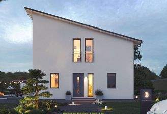 Dieses massa haus Fertighaus Einfamilienhaus im Lifestyle-Design präsentiert sich bei Dämmerung mit