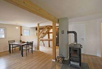 Fachwerkdetails und Kamin bringen charmante Gemütlichkeit im offenen Essbereich