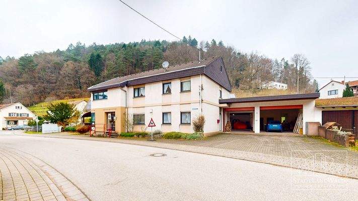 Haus Vorderseite mit großen Garagen und Stellplätzen