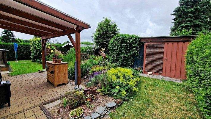 Blick in den Garten mit überdachter Terrasse