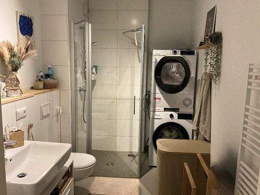 Badezimmer, weiß gefliest und Dusche mit Glasduschwand