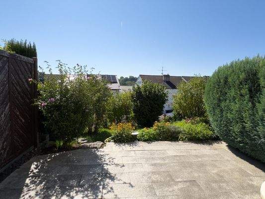 sonnige Terrasse mit Garten