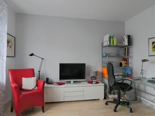 Sessel, TV und kleiner Schreibtisch