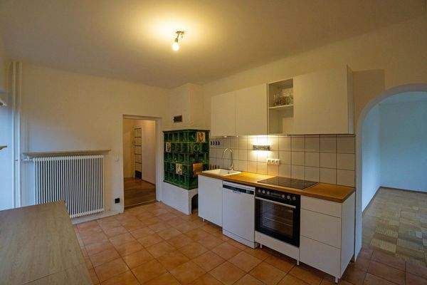 Küche mit Kachelofen und Ausgang auf die straßenseitige Terrasse