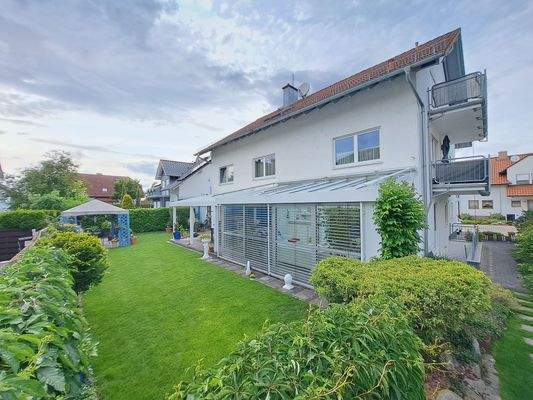 Gartenansicht mit beschattetem Wintergarten