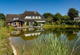 Blick über den großen Badeteich zum Haus