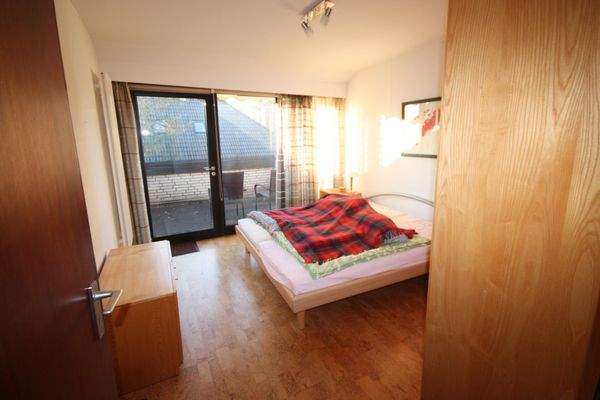 Schlafzimmer mit Balkonzugang in der Dachgeschosswohnung