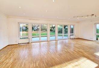 Große Fensterfront im Wohnzimmer mit schönem Gartenblick