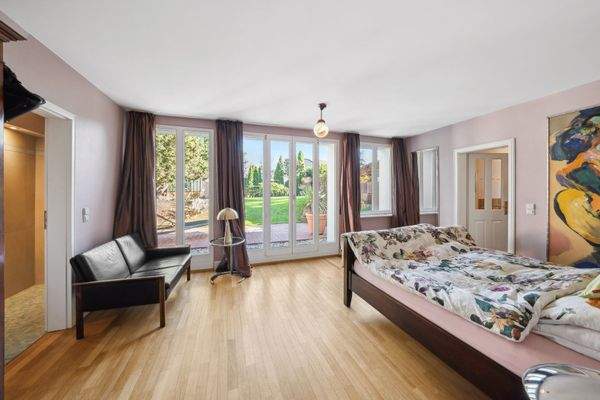 Aufwachen mit Blick ins Grüne - das Master-Schlafzimmer mit direktem Gartenzugang, Bad en Suite und Einbau-Sauna.