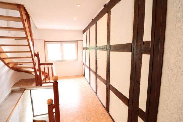 Treppenhaus mit warmen Holzbalken, massiver und ho