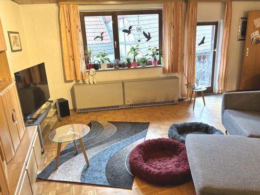 helles Wohnzimmer mit Parkettboden und Balkonzugang im Obergeschoss