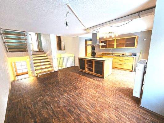 Große Wohnküche mit Ausgang zur Terrasse mit Garten