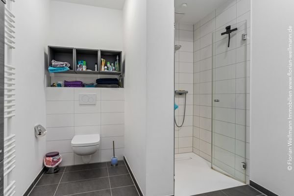 Badezimmer mit Dusche und Handtuchwärmer.