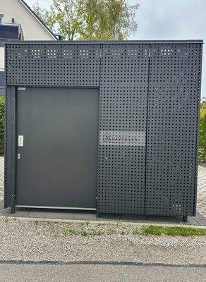 Fahrrad und Mülltonnenhaus