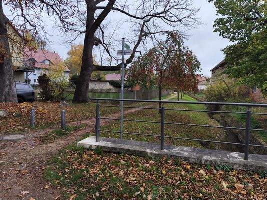 seitlich angrenzender, öffentlicher Weg mit Bachlauf