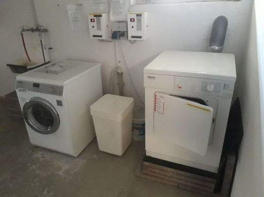 Münzwaschmaschine und Trockner im Keller