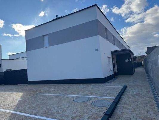 Parkplatz vor der Anlage mit nur 4 Reihenhäusern