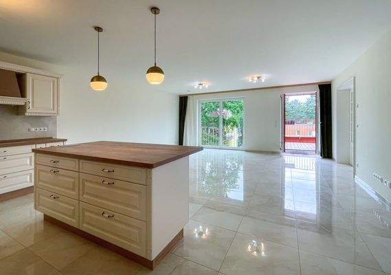 Wohnzimmer mit Balkon und offener Küche