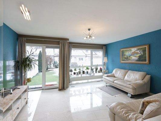 Schönes Wohnzimmer mit großen Fenstern zum Garten