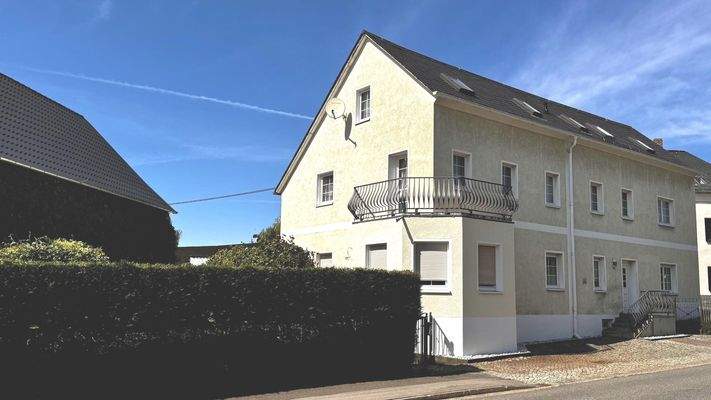 Straßenansicht mit Balkon WG 1