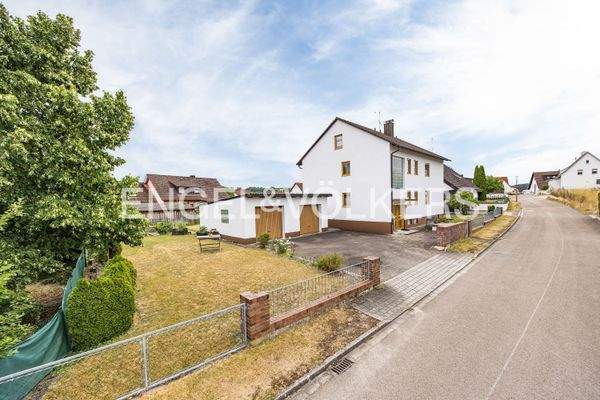 Straßenansicht auf die Immobilie mit Doppelgarage und sehr großem Grundstück mit Potenzial