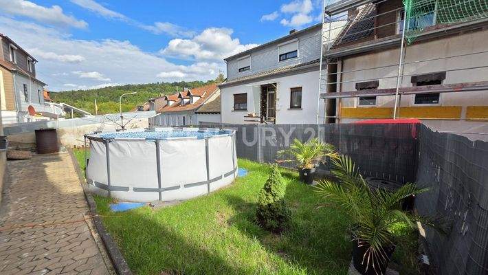 Gartenbereich mit saftig grüner Wiese hinter dem Haus