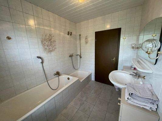 das Bad mit Badewanne und Dusche