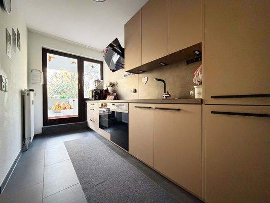 Die Einbauküche nutzt den Raum optimal aus und bietet schöne Arbeitsflächen und viel Stauraum