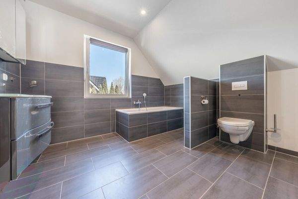 Das warm gehaltene Badezimmer verfügt über Badewanne