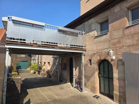 Sandsteinhaus mit Fokus auf die Terrasse der Maisonette-Wohnung