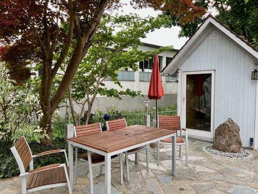 Sitzecke mit Quellstein und Gartenhütte