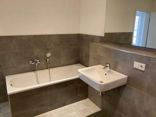 Referenzbild Bad mit grauen Fliesen Wanne Waschtisch.JPG