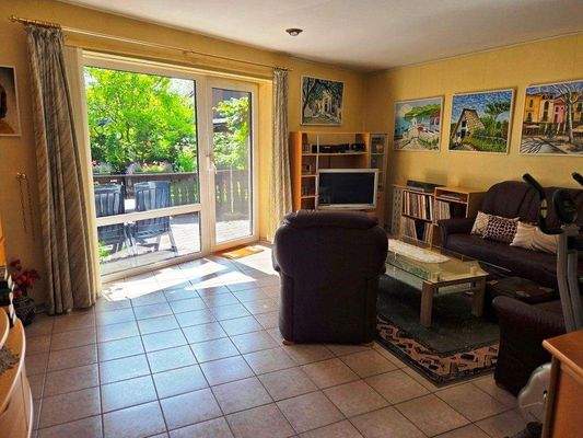 Wohnzimmer mit raumhohen Fensterelement zur Terrasse und Möglichkeit einen Kaminofen in einer Ecke aufzustellen.