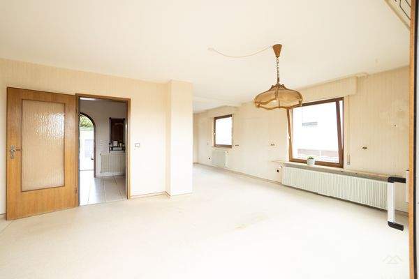 Wohnzimmer mit Balkonzugang und Wintergarten