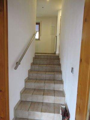 gefliestes Treppenhaus mit Edelstahlgeländer 