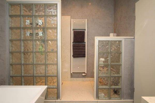 BAD MIT SPLIT LEVEL FLOORING, BLICK AUF DUSCHE (li.) + WC (re.)