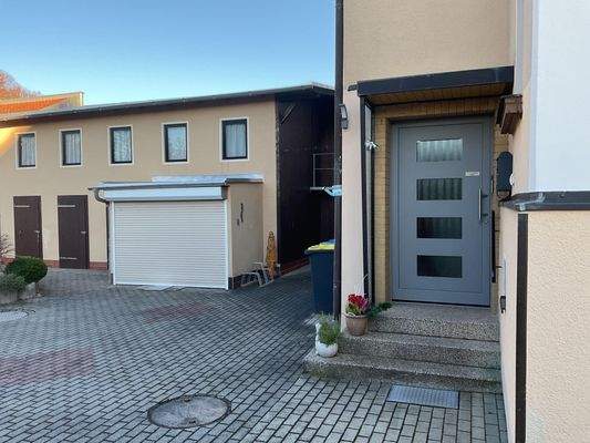 Hauseingang und Nebengebäude mit Garage