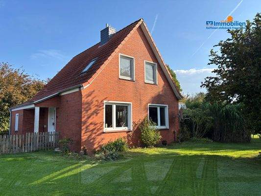 Hausansicht vom Garten auf der Echten Seite mit Bäumen und grünem Gras im Vordergrund