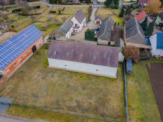 großer Pferdestall mit Wiese