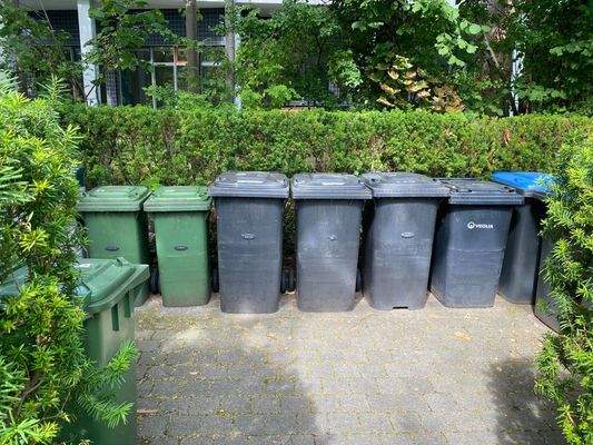 mit Grün umrandeter Stellplatz für die Mülltonnen