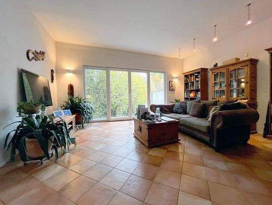 Wohnzimmer mit Kamin und Balkon am Bachlauf