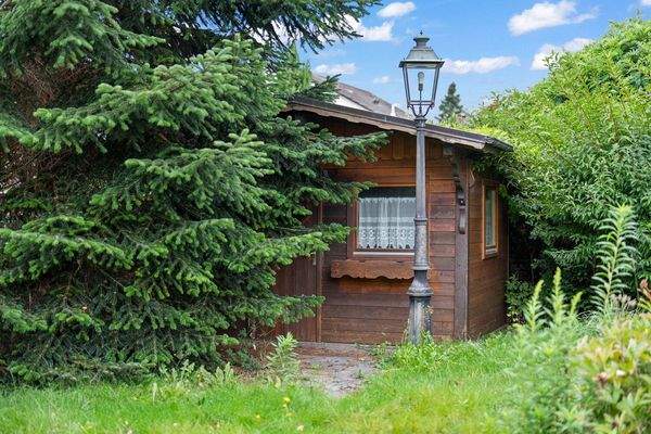 Blick auf das Gartenhaus mit altem Baumbestand 