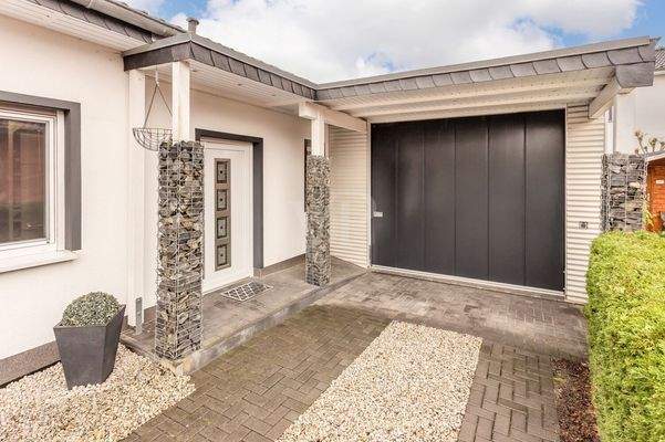 Blick auf den überdachten Eingangsbereich und die Garage